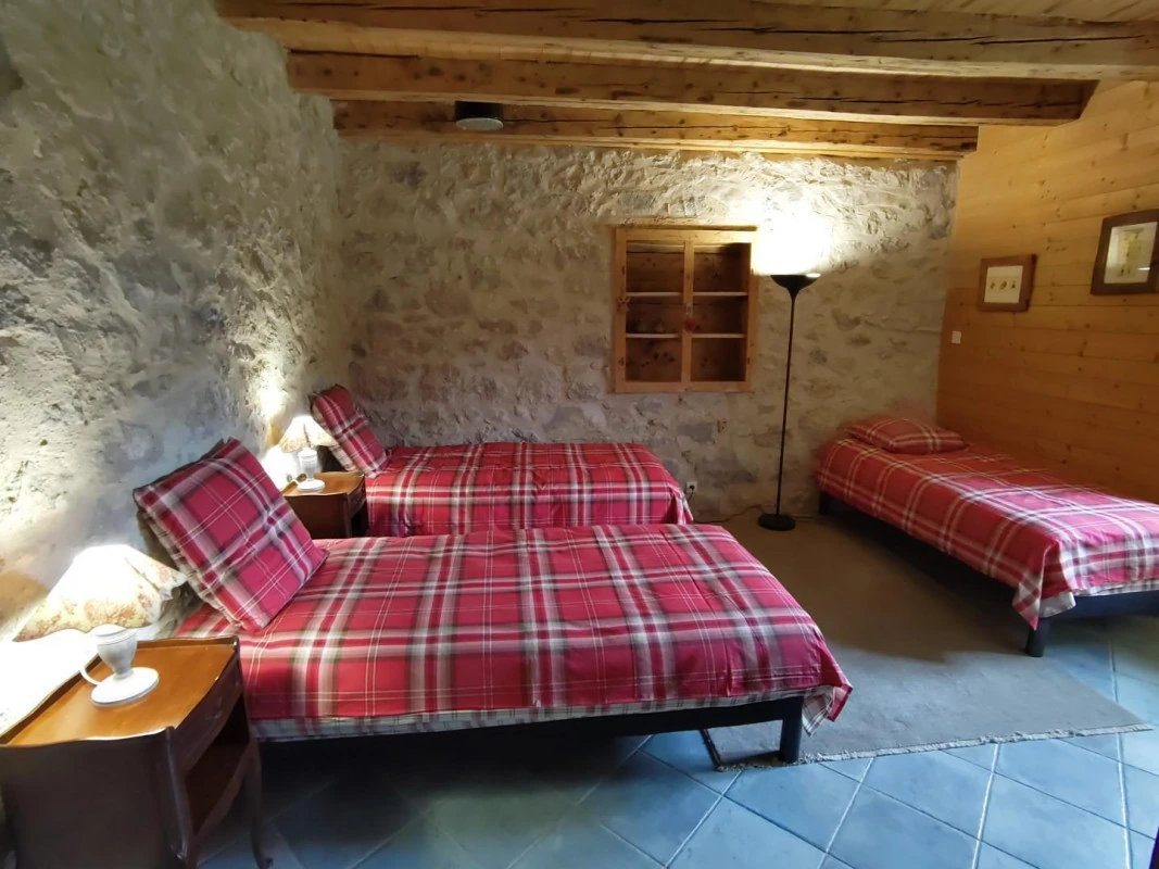 Agrandir : Le lit simple et le mur en pierre de la seconde chambre