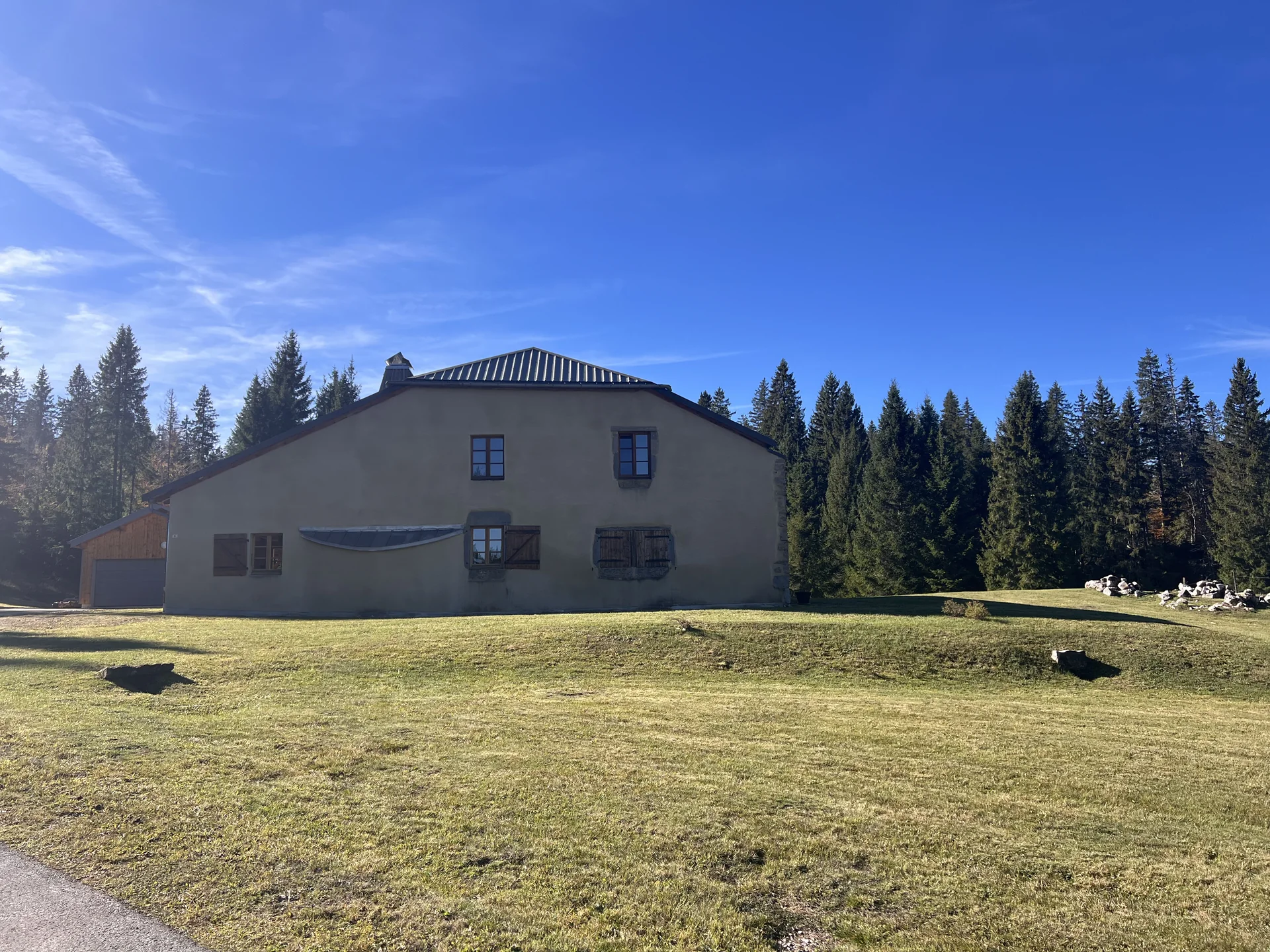 La maison et le jardin du Refuge de la Toumire entourés de sapins