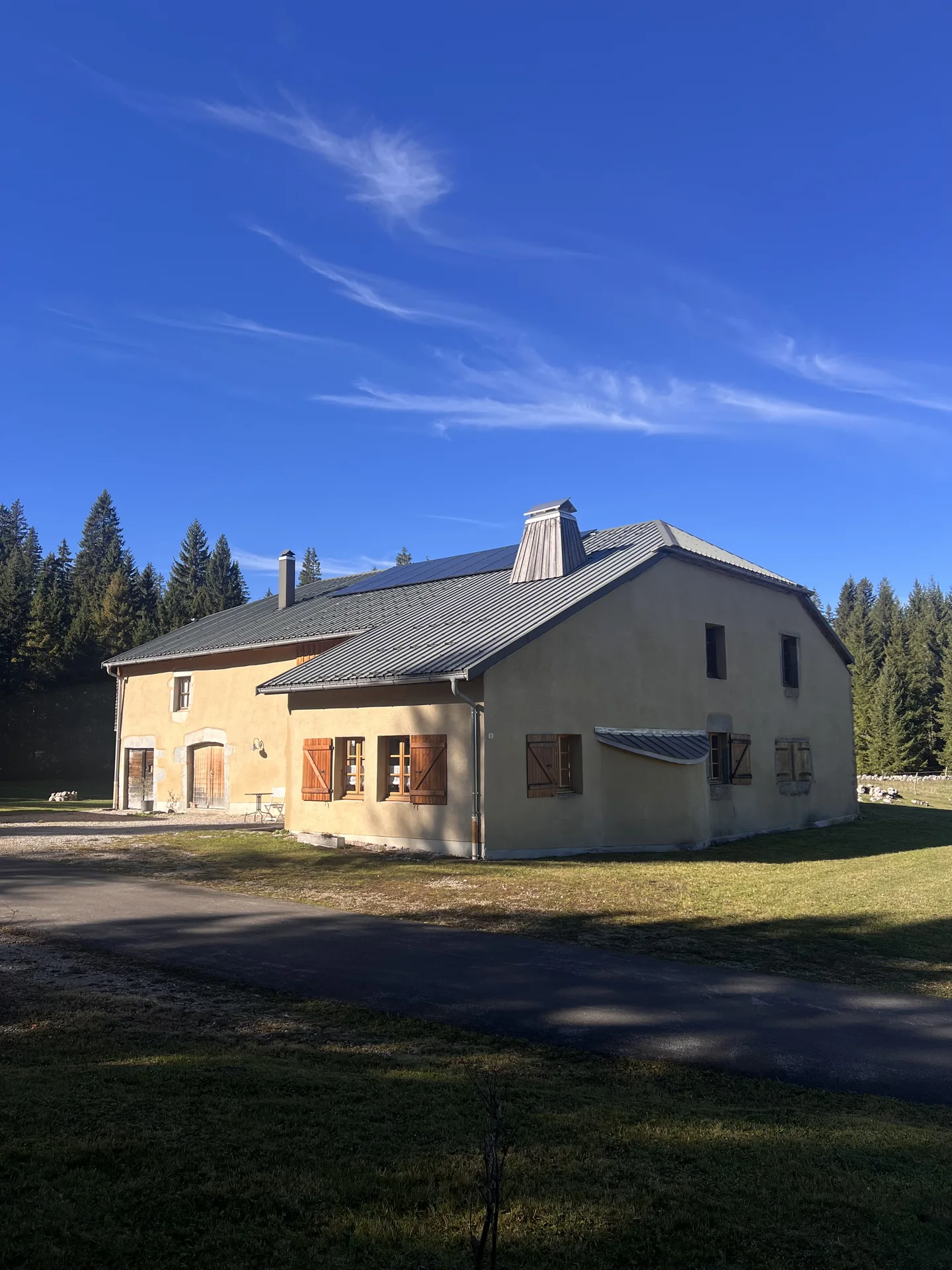 Agrandir : Vue extérieure du Refuge de la Toumire et des sapins à Chapelle-des-Bois