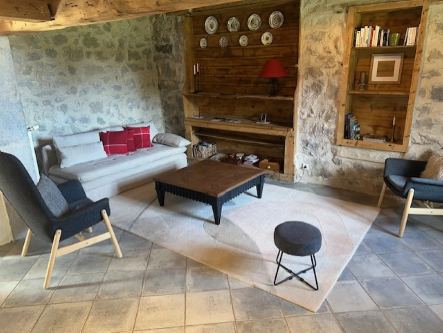 Le séjour avec canapé et mur en pierre